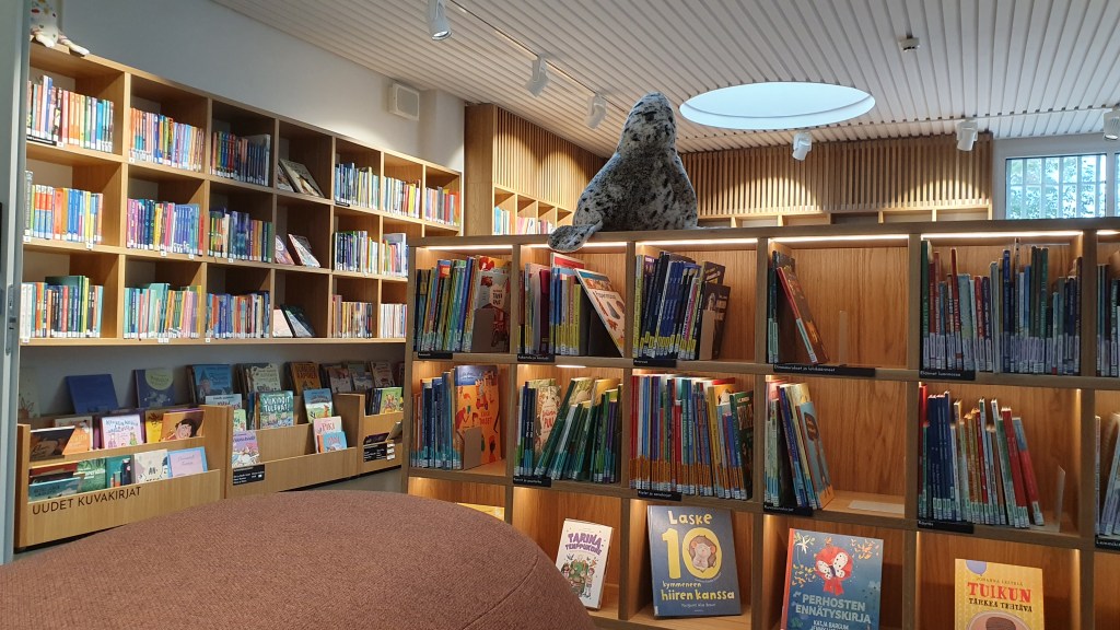 Rovaniemen pääkirjaston lastenosaston hyllyjä, joissa kirjoja ja pehmoleluja.